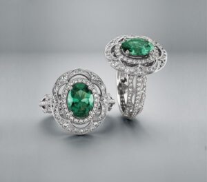 Two emerald rings with diamond halos and ornate settings