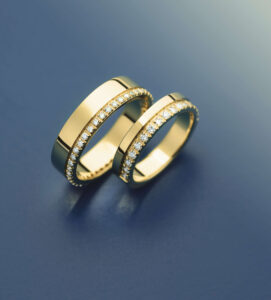 Gold diamond wedding rings on dark background